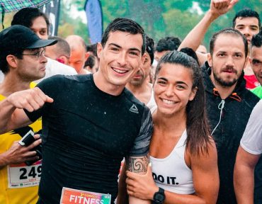 Group of runners smiling in the rain during a marathon race event.